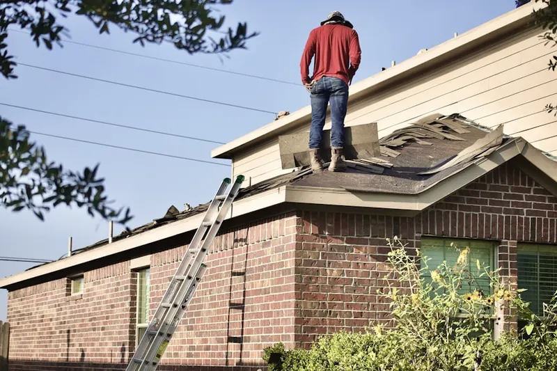 Professional roofer working on a residential roof in Stone Mill